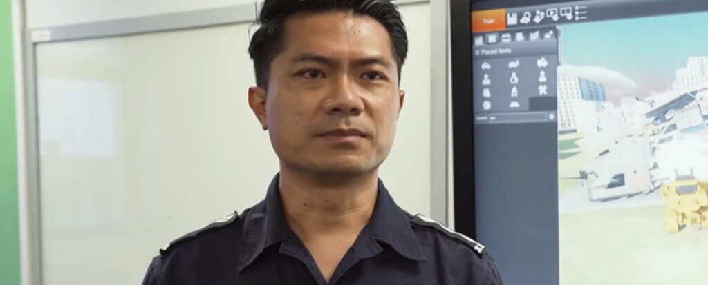 A Singaporean policeman standing in front of a screen displaying XVR OS