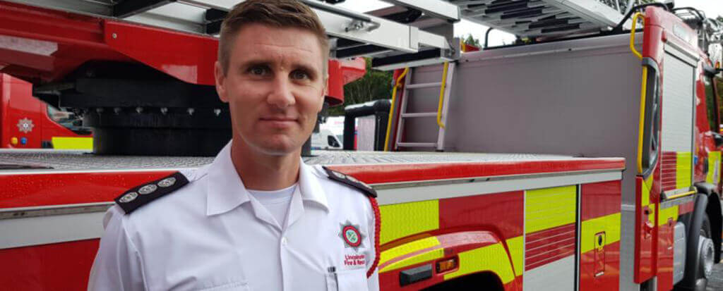 A firefighter standing in front of an firetruck