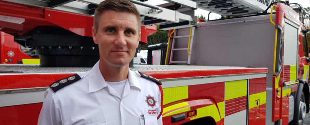 A firefighter standing in front of an firetruck