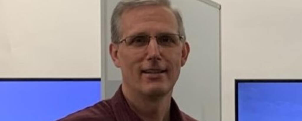 A profile picture of a man with glasses